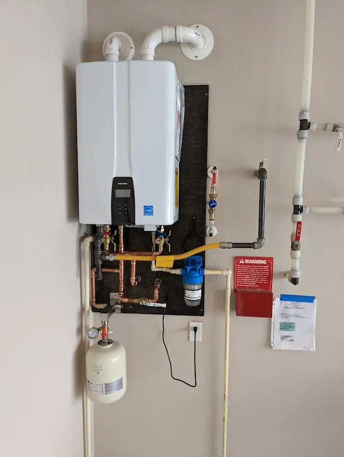 Professional plumber installing copper piping in a Spencer home